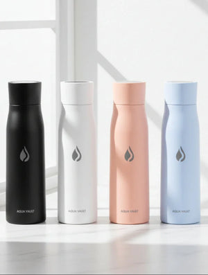 Four AQUA VAULT PureX smart water bottles in black, white, pink, and blue on a light surface with a window in the background.