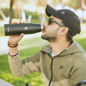 Indian Man drinking from Black Premium Water Bottle AQUA VAULT PureX Self-Cleaning Smart Water Bottle.