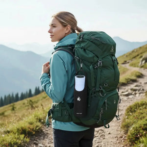 Woman hiking with a green backpack and AQUA VAULT PureX Water Bottle on a mountain trail