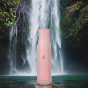 AQUA VAULT PureX Self-Cleaning Smart Water Bottle in Pink color in front of a waterfall