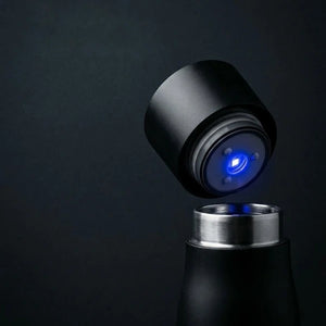 Black AQUA VAULT PureX UV-C Self-Cleaning Smart Water Bottle with a UV light on a dark background