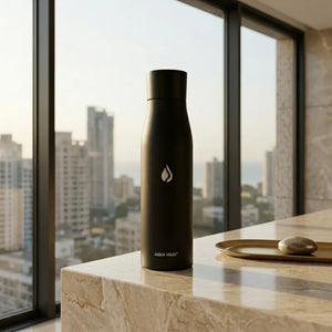 Black AQUA VAULT PureX UV-C Self-Cleaning Smart Water Bottle on a marble surface with a cityscape view.