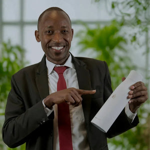 Man in a suit holding AQUA VAULT PureX White Bottle with a blurred green background